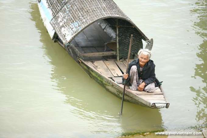 An old woman on a bamboo boat