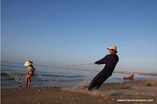 Fishermen pulling fishnet on Mui Ne beach