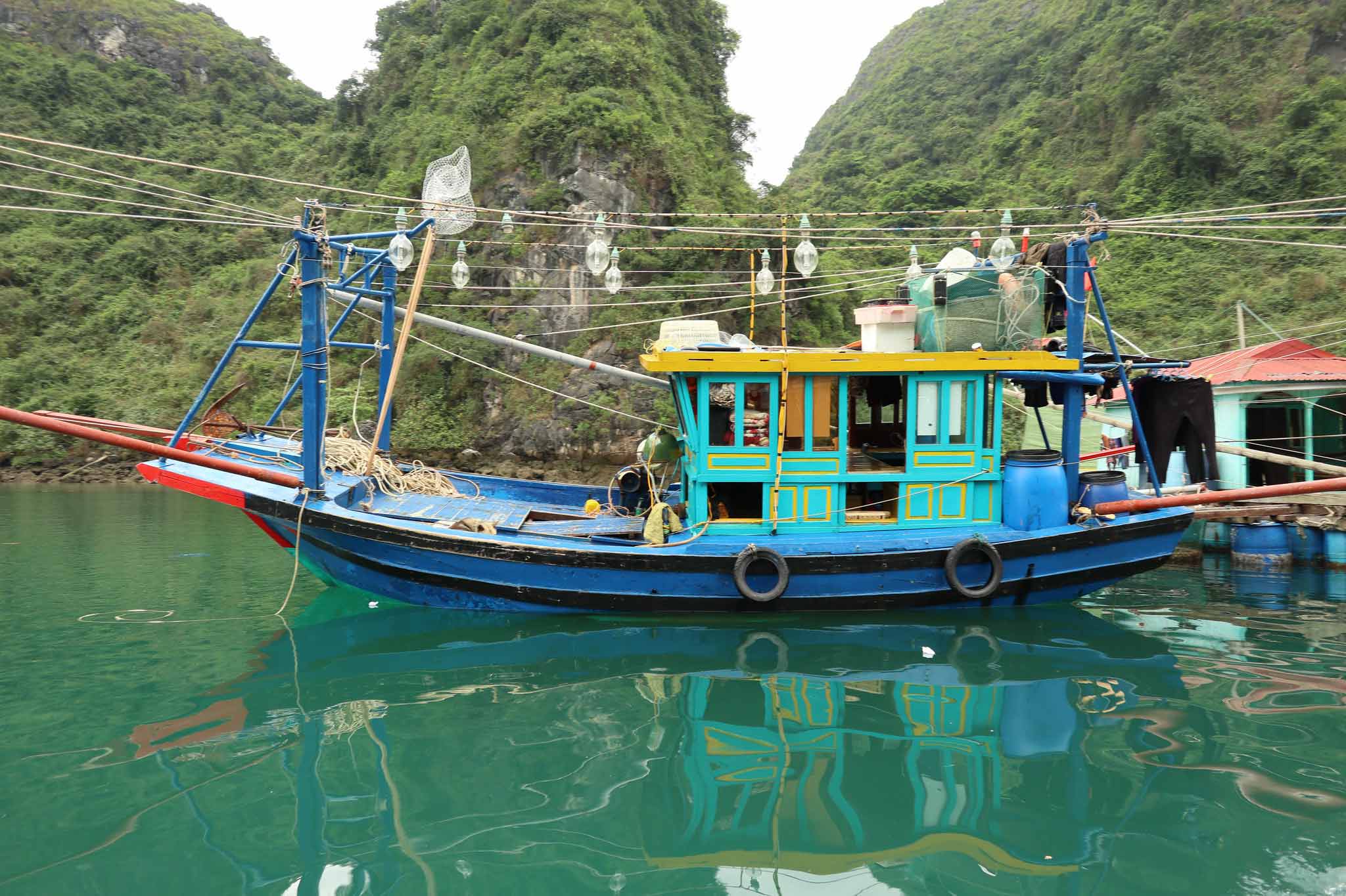 A boat sailing in the clear waters of Ha Long Bay in summer