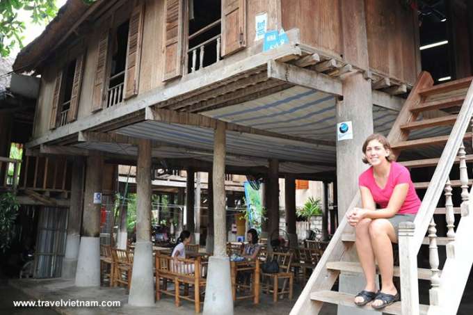 A foreign tourist visits a stilted house