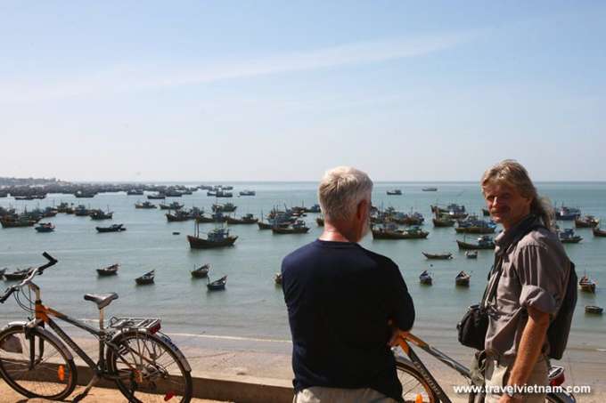 Foreign tourists biking along Mui Ne fishing village